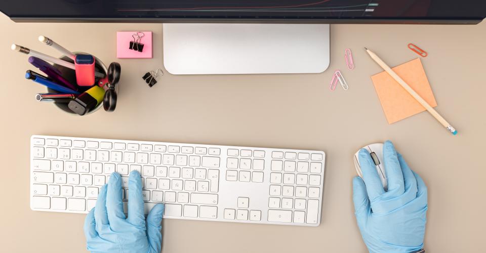 hands with protective glove typing on keyboard com PTXL56T min